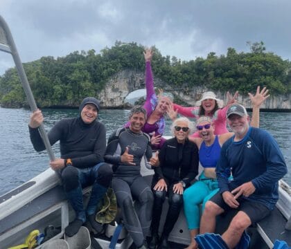 travelers pose on a boat in Palau