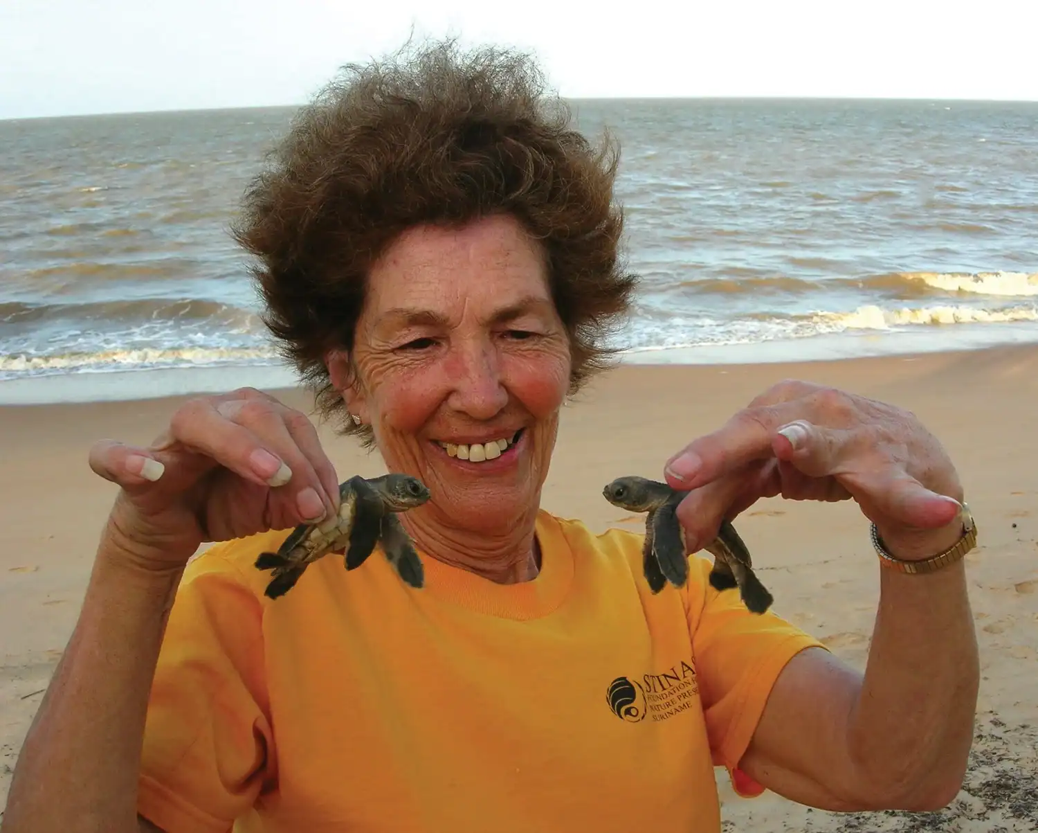 Nancy Wotkyns Legacy donor Nancy Wotkyns poses with hatchling sea turtles during an Oceanic Society trip in Suriname.