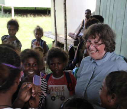 traveler visiting young children at Solomon Island school