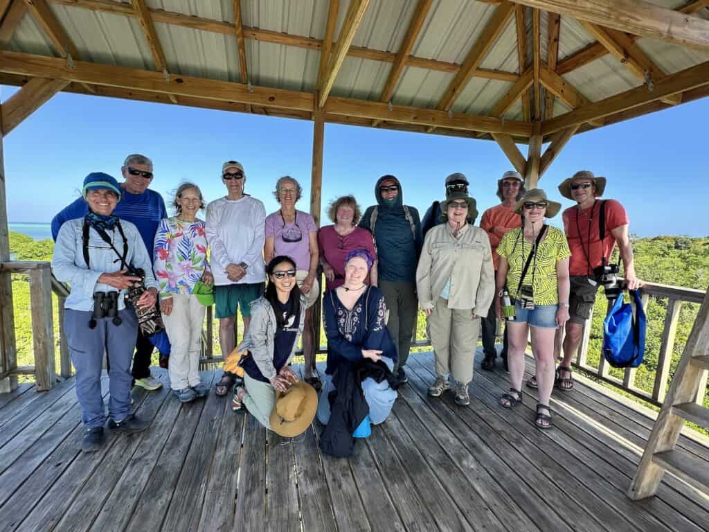 Solo travelers pose together on an Oceanic Society expedition in Belize, smiling and enjoying the experience as a group.