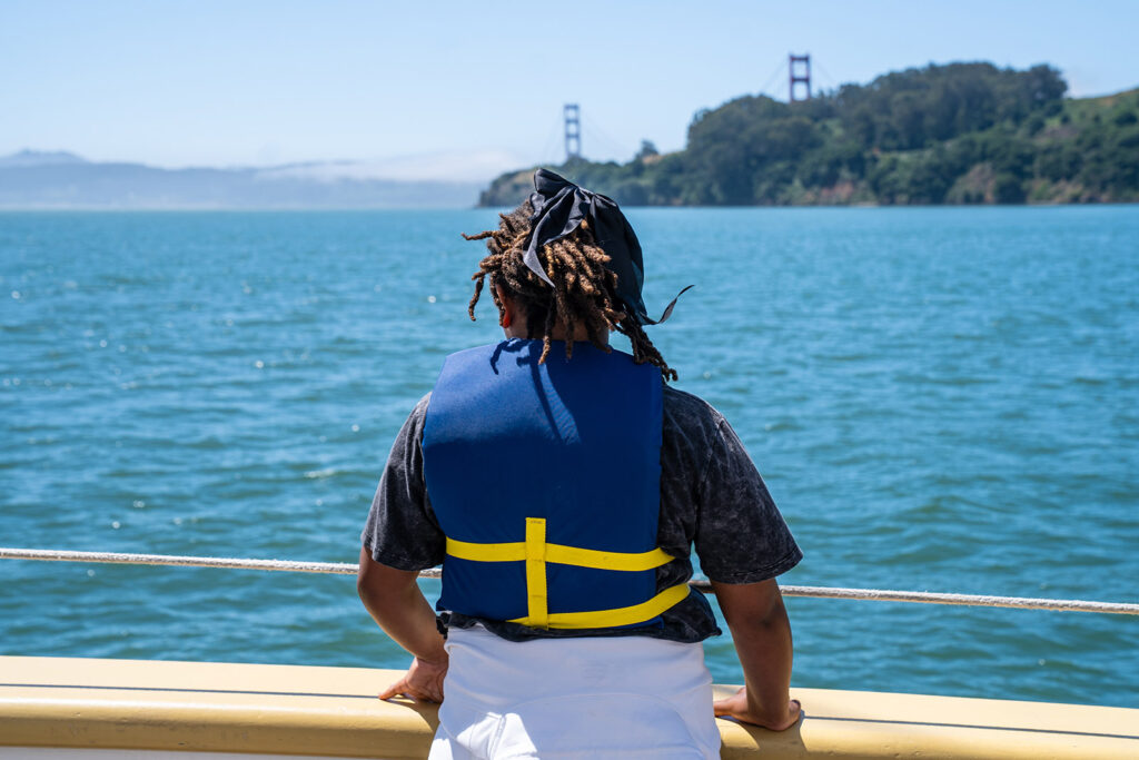 student looks at San Francisco Bay from a boat