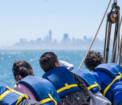 students on a boat look at the san francisco skyline