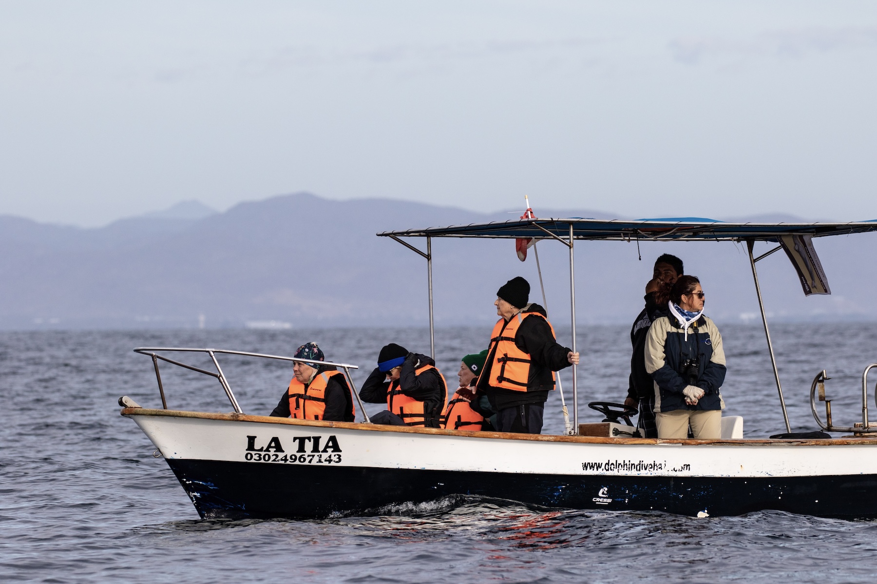 Whale watching passengers in orange life vests aboard the panga La Tia in Loreto