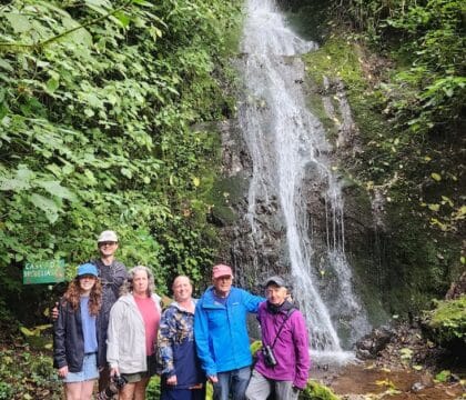 Family group photo in front of a waterfall in the Costa Rica cloud forest